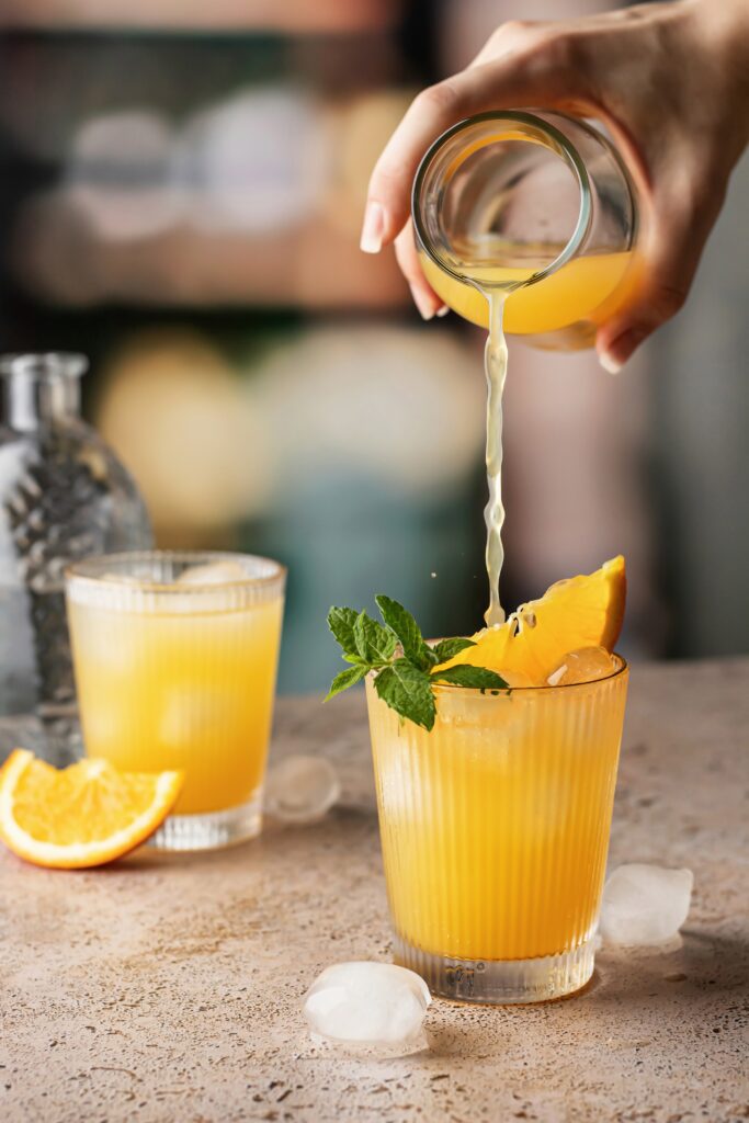 Orangenlimo in schönem Glas mit Eis und Minzeblättern. 