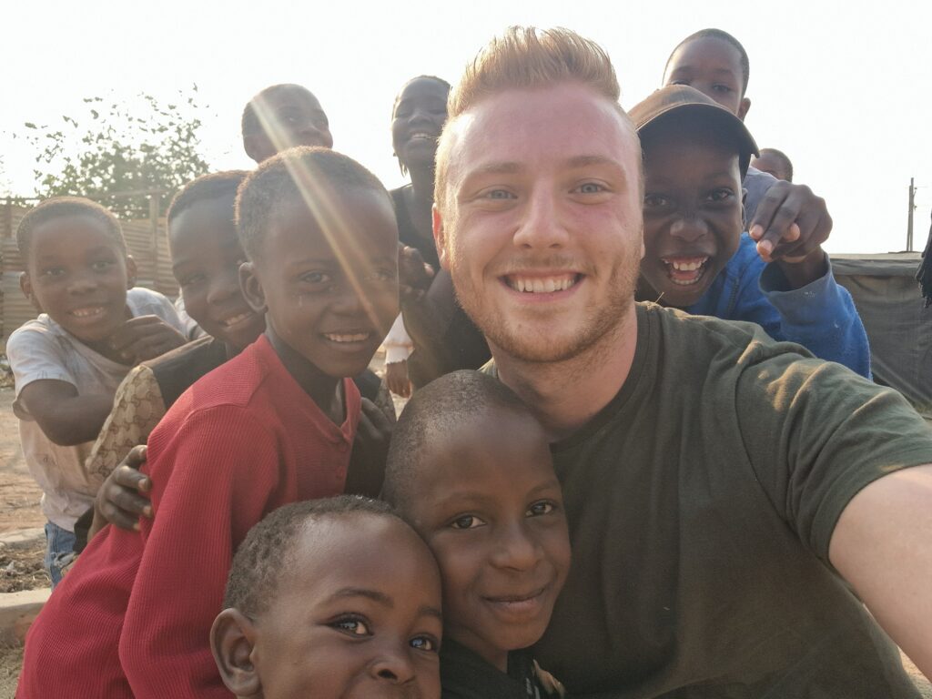 Gabriel Reifinger inmitten von Kindern in Afrika