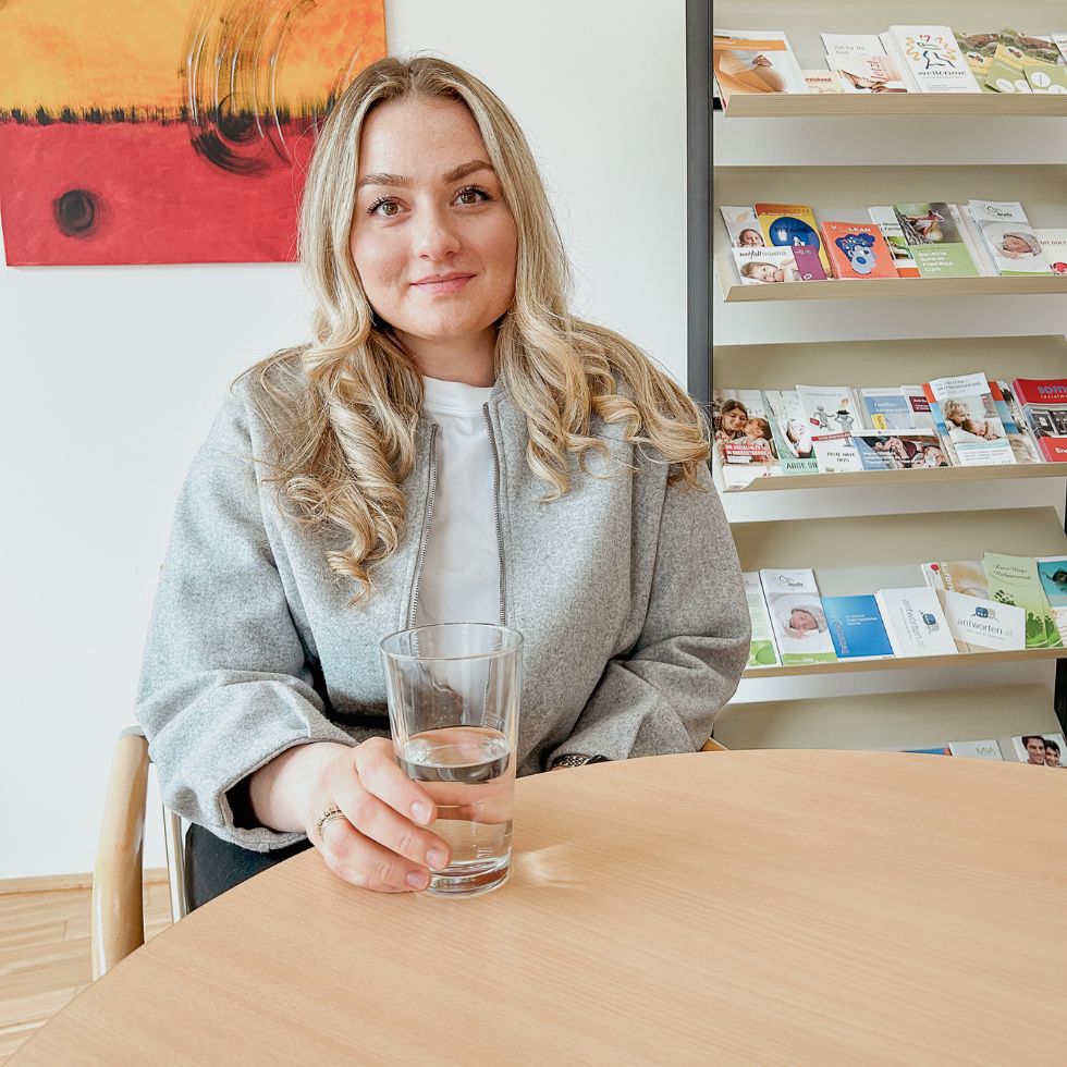 Junge Frau sitzt an einem Tisch