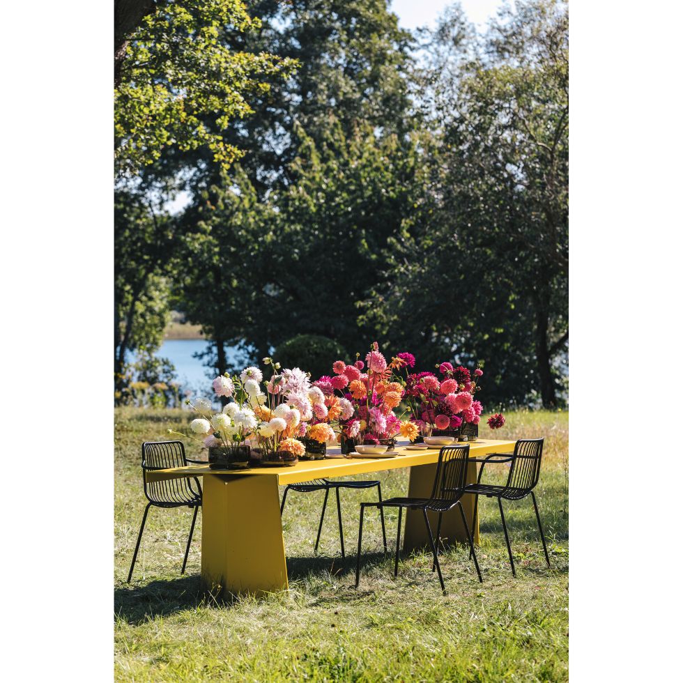 Dekotipps Sommerparty: Ein gelber Tisch mit mehrfarbigen Dahlien darauf