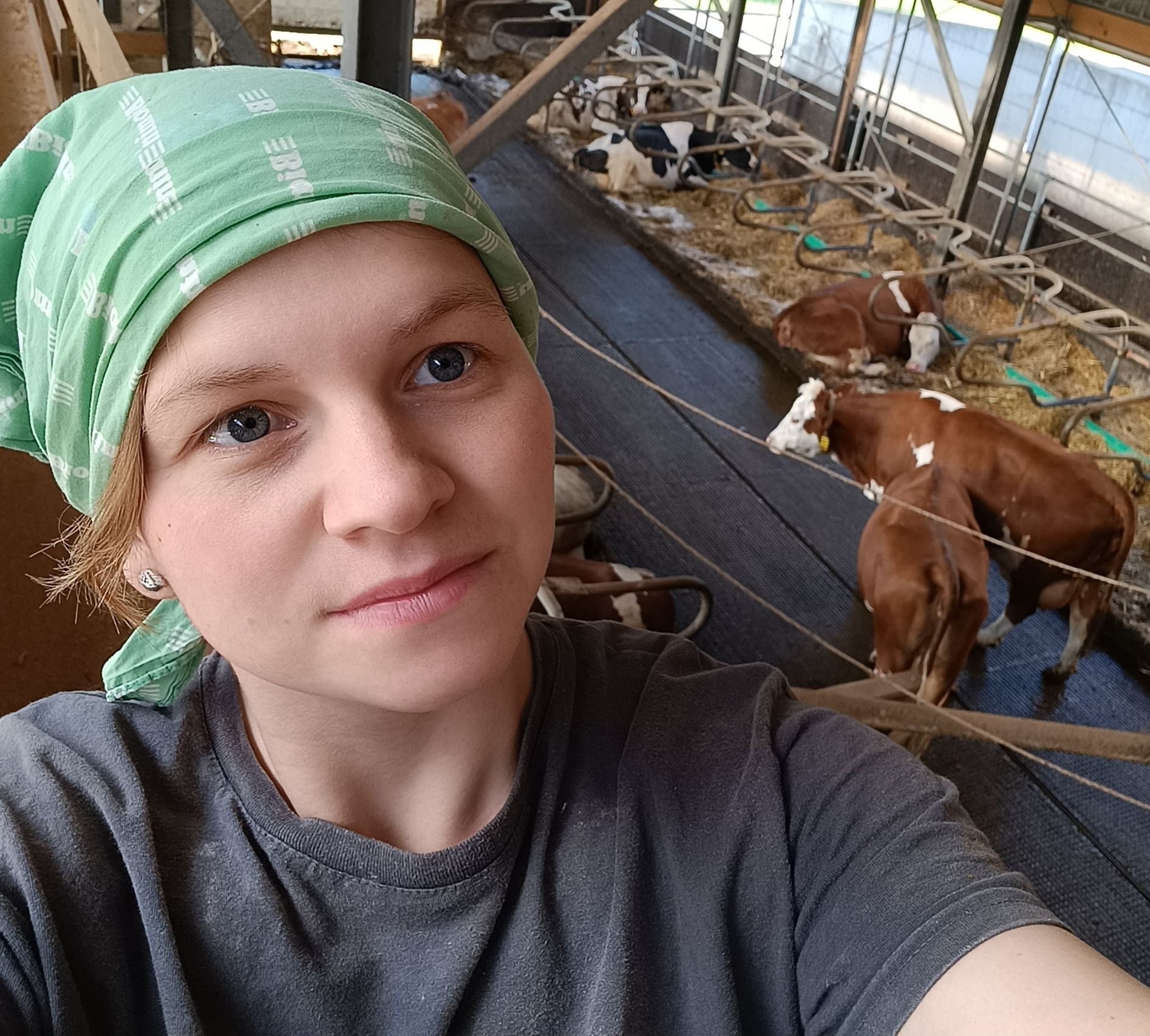 Bäuerin Angelika Wieser im Stall mit Kühen im Hintergrund.