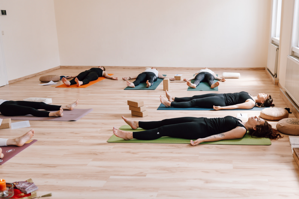 Yoga-Ausbildung in Oberösterreich: Gruppe von Frauen liegt am Boden