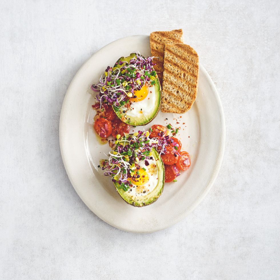 Gebackene Avocado mit Ei und Sprossen.