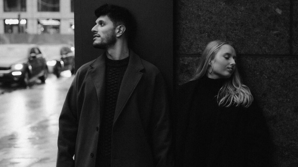 Mann und Frau stehen nebeneinander und schauen voneinander weg