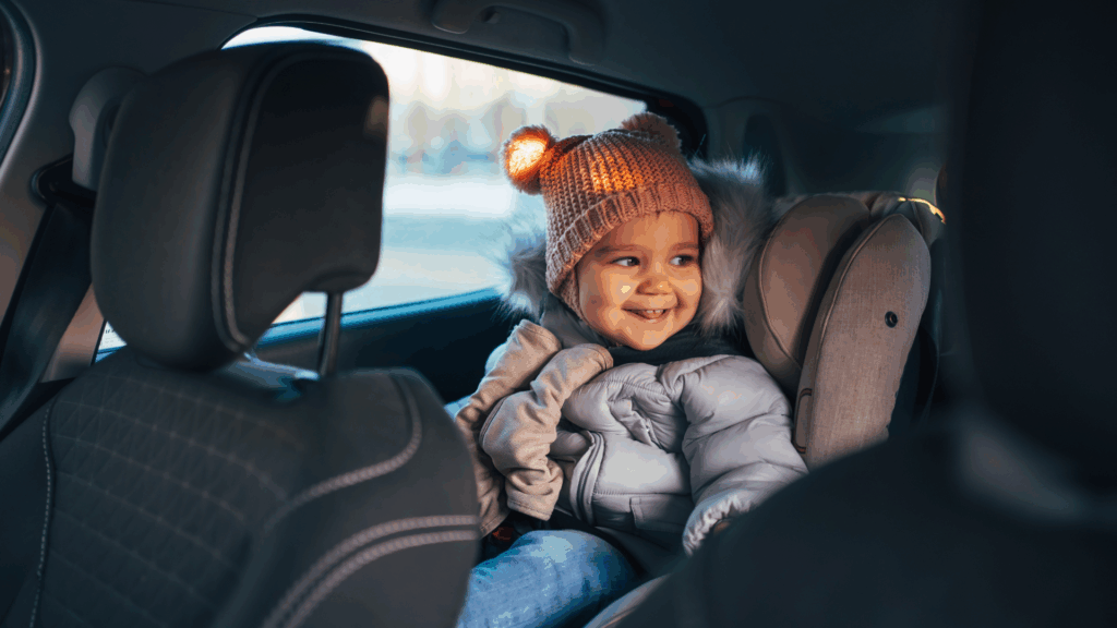 Kind im Autokindersitz lächelnd