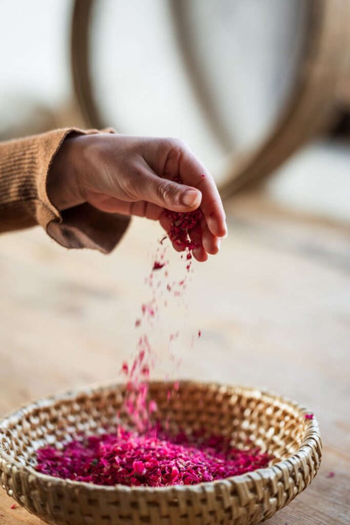 Getrocknete Rosenblüten, die in eine Schüssel rieseln