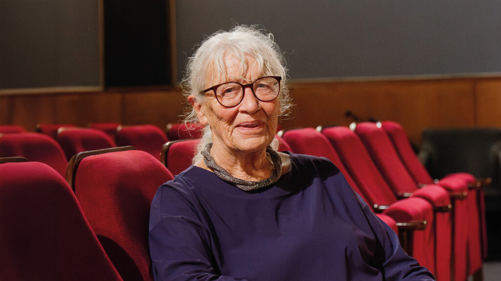 Autorin Jutta Treiber sitzt im Kinosaal und spricht über ihre Verbindung zum Kino sowie ihre literarische Arbeit.