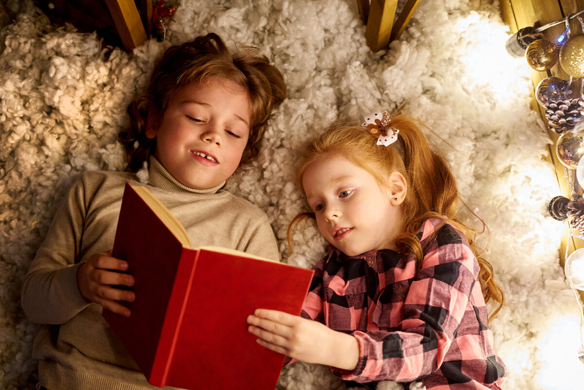 KinderbÃ¼cher: Junge und MÃ¤dchen lesen gemeinsam ein Buch auf dem Boden